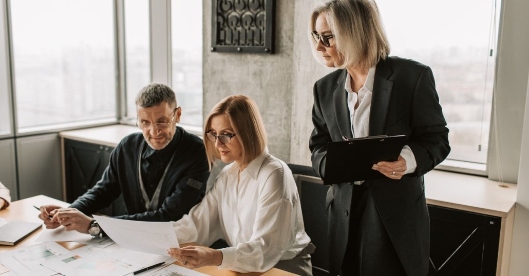 Three professionals looking at paperwork together illustrating Alexandria, Virginia IT consulting services for small businesses