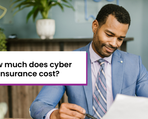 How much does cyber insurance cost? Background: Black man in blue suit holding document and pen