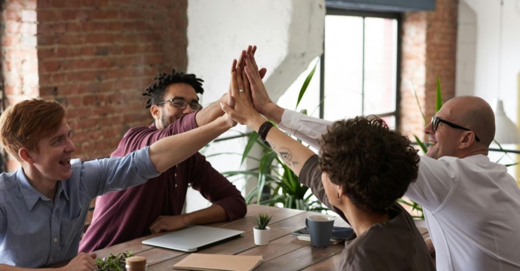 Group of co-workers giving a group high-five