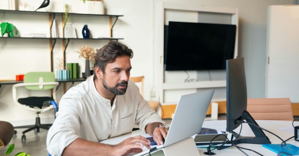 man working with multiple computers
