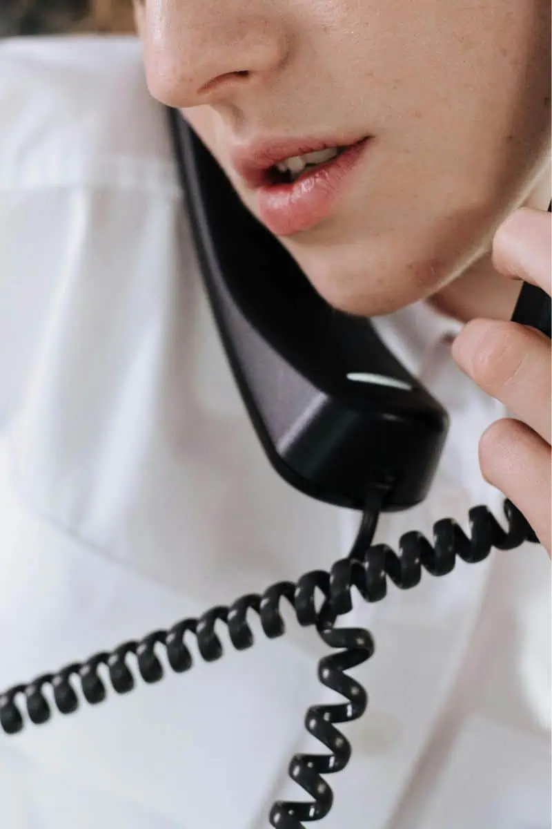 Woman holding two desk phones