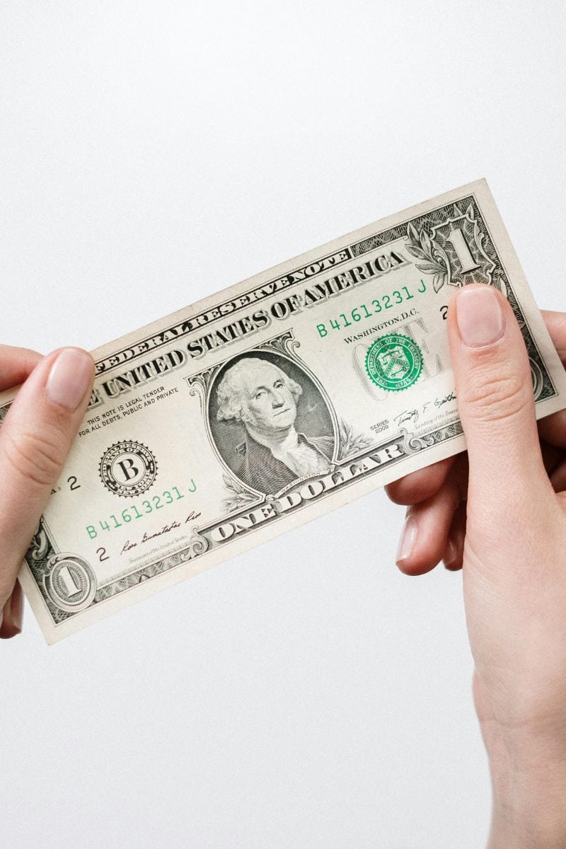 Business VoIP cost savings Hands holding dollar bill - illustrating VoIP cost savings